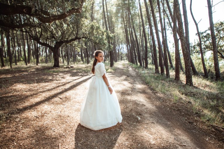 niña vestida de comunion en un bosque